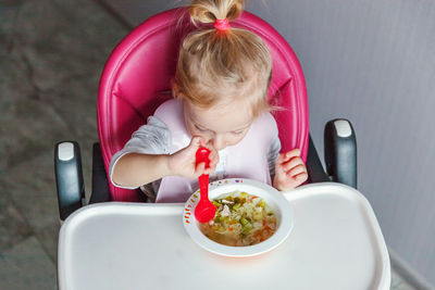 High angle view of cute girl sitting on table