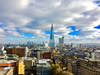 Modern buildings in city against cloudy sky