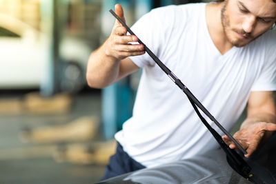 Man checking windshield wiper at garage