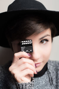 Close-up portrait of young woman holding film slate toy