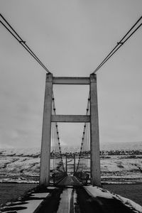 Suspension bridge over sea against sky