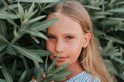 Portrait face of candid happy little kid girl of eight years old with long blond hair and green eyes