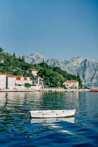 Scenic view of sea and mountains against clear blue sky