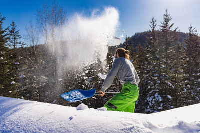 Man standing on snow covered mountain against sky