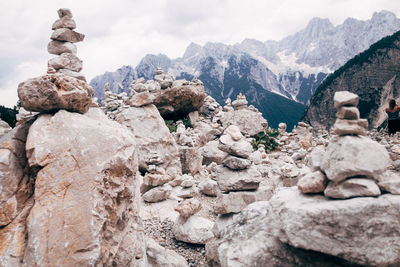 Rocks on mountain against cloudy sky