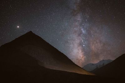 Low angle view of mountain against sky at night