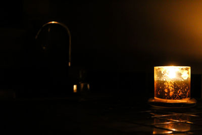 Close-up of lit candle in dark room