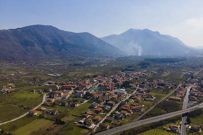 High angle view of townscape and mountains against clear sky