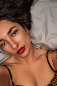 Close-up of young woman lying on bed at home