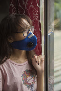 Portrait of girl looking through window