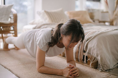 Side view of boy sleeping on bed at home