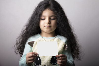 Portrait of smiling young woman using mobile phone against wall