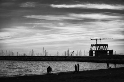 Silhouette people on pier by sea against sky, dock of salerno in italy 