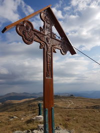 Cross on land against sky