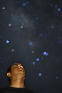 Low angle view of man in illuminated lamp