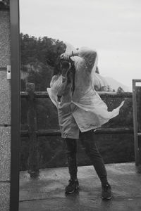 Rear view of woman standing with umbrella