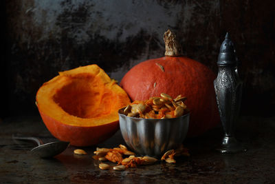 Close-up of pumpkin seeds in bowl with drink on table