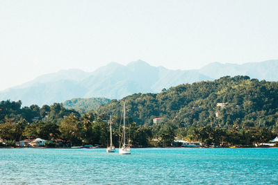 Scenic view of sea and mountains against clear sky