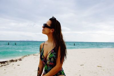 Man wearing sunglasses at beach against sky