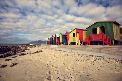 Beach huts by buildings against sky