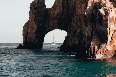 Rock formations by sea against sky