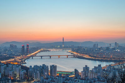 Illuminated buildings in city during sunset