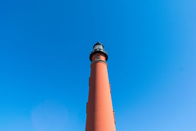 Low angle view of lighthouse against clear blue sky