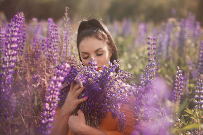 Low angle view of woman with pink flowers on field