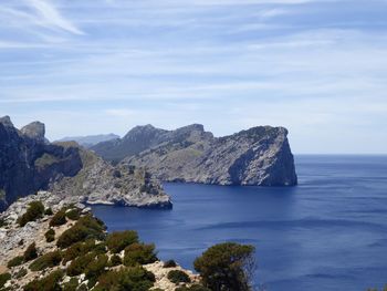 Scenic view of sea and mountains against sky