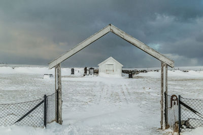 Built structure on snow covered land against sky