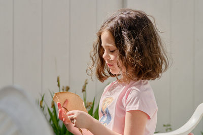 Expressive young girl is having snacks in the backyard