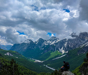 Rear view of person on snowcapped mountains against sky