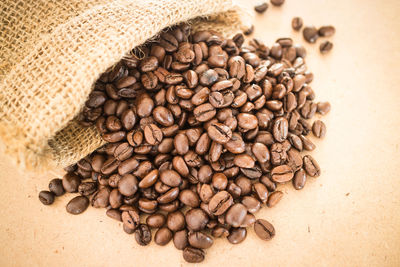 Close-up of roasted coffee beans spilling from jute bag