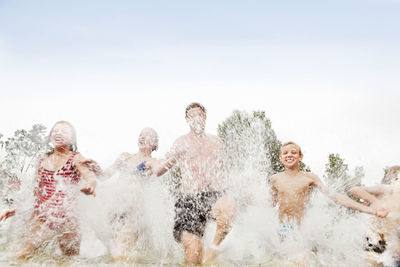 Man with kids running in lake