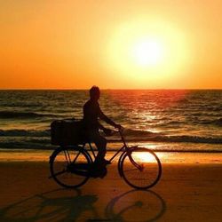 Silhouette of people in sea at sunset