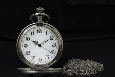 Close-up of pocket watch against black background