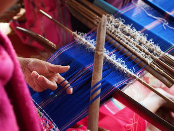 Midsection of woman working on loom