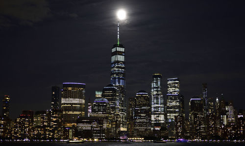 Illuminated buildings against sky at night