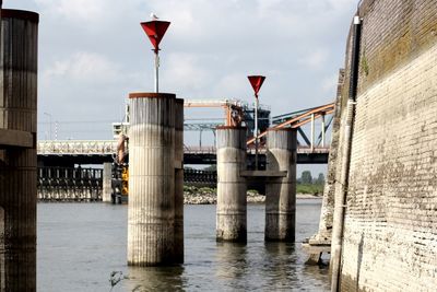 Bridge over river in city against sky