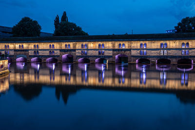 Reflection of illuminated bridge in water at night