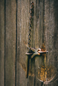 Close-up of rusty chain hanging on wooden door