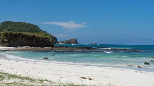 Scenic view of beach against blue sky