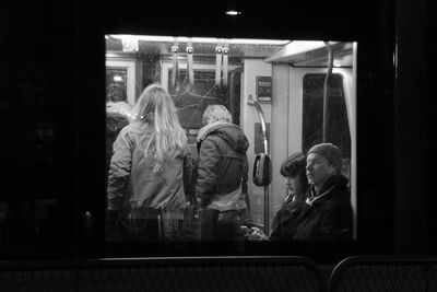 Rear view of people looking through window