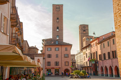 Group of people on street against buildings in city