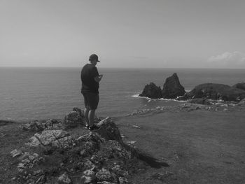 Rear view of man looking at sea against sky