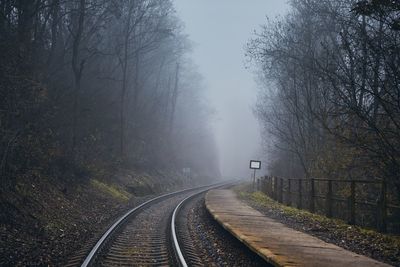 Railway in mysterious fog. old railroad station in the middle of forest in autumn.