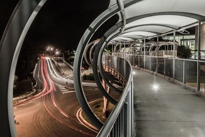 Light trails on footbridge in city at night