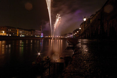 Fireworks in pisa are lighting arno river by night 