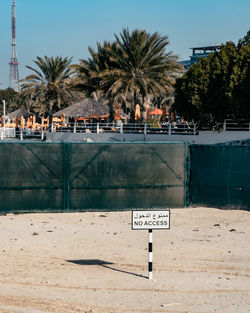 Information sign by swimming pool against sky