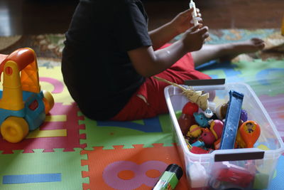 Low section of boy playing with toys 